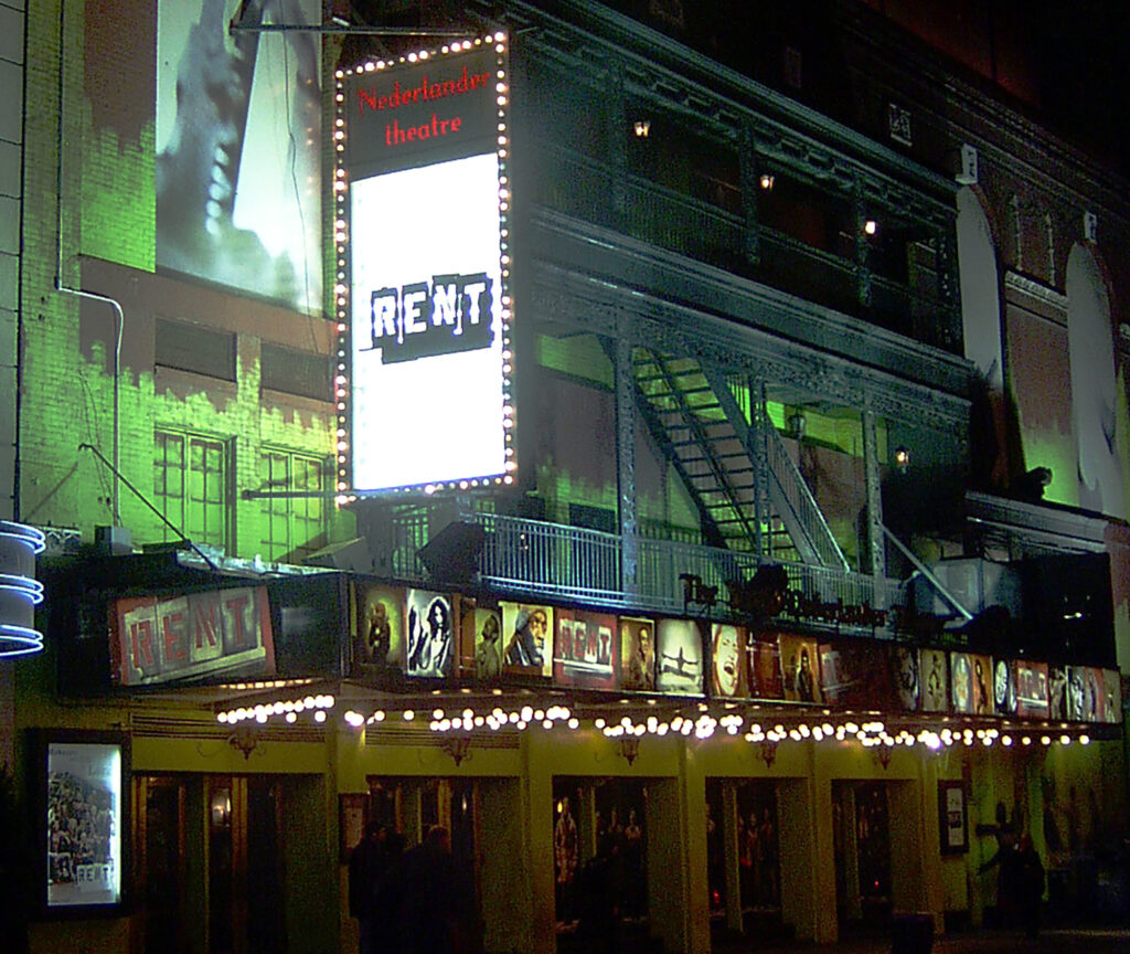 Night time image of the marquee at the Nederlander Theatre showcasing RENT.