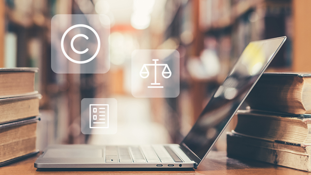 a laptop sits in front of old books and bookcases with a copyright symbol and law weights floating in front of it.
